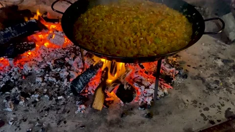 Paella cooking on an open flame Stock Footage 168833684