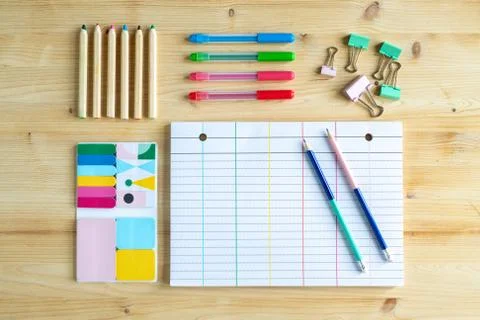 Page of notebook with two pencils and clips, sets of crayons and erasers Stock Photos