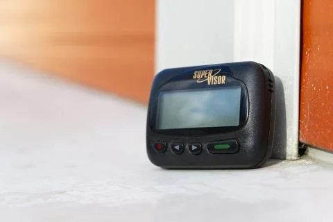 Pager Super Visor on wall background. Portable wireless device for text messages 스톡 사진