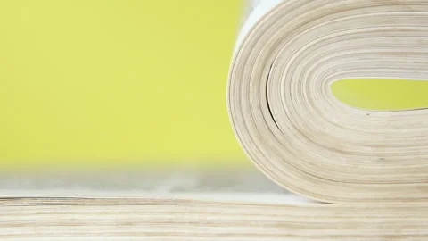 Pages of a book falling and turning over in slow motion. On a bright colored  Stock Footage 155253181