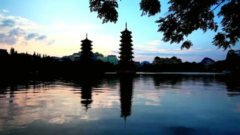 Pagodas reflect in the lake at sunset, creating a tranquil scene Stock Footage 312304482