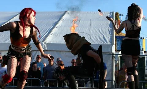 Paignton, Devon, England: Fire-breathing troupe dance around man's head on fire 스톡 사진