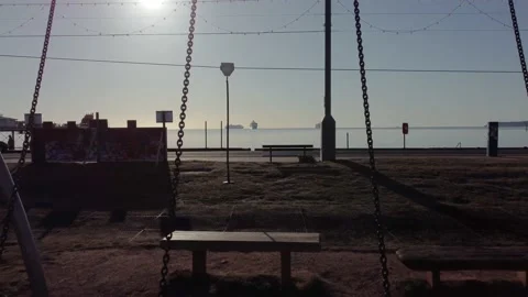 Paignton SeaFront at Sunrise - Tracking Forward Through Swing Stock Footage 155101392