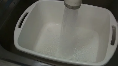 Pail being filled with water Stock Footage 84458238