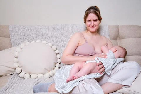 Pain and problems in a woman while breastfeeding a baby. Mother experiences d Stock Photos