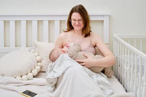 Pain and problems in a woman while breastfeeding a baby. Mother experiences d Stock Photos
