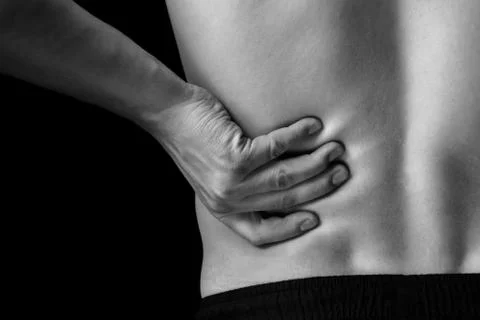Pain in the lower back, close-up Stock Photos