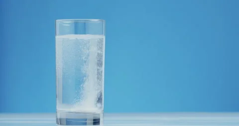 Pain Relief Tablet Dissolving In Water Macro Close Up Blue background Stock Footage 326173547