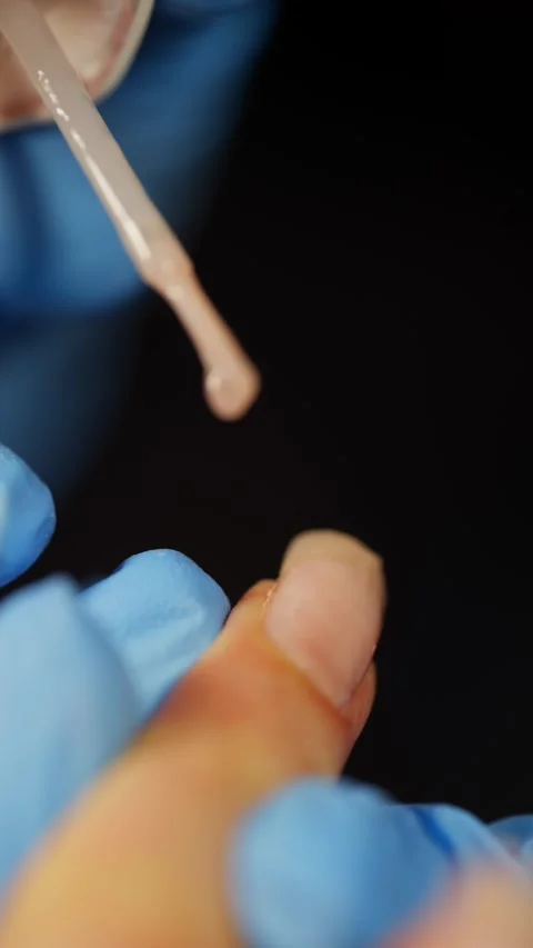 Painstaking work on applying the base to the nail plate. Stock Footage 322130736