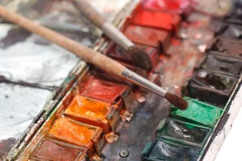 Paint box with messy brushes Stock Photos