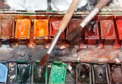 Paint box with messy brushes Stock Photos