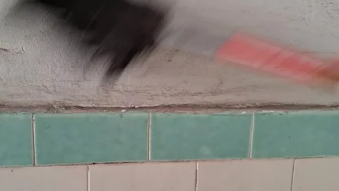 Paint brush applying dark grey paint on tiled bathroom wall video Stock Footage 339247453
