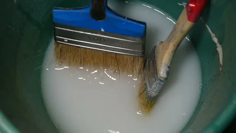 Paint brush in a bucket with a primer Stock Footage 169253687