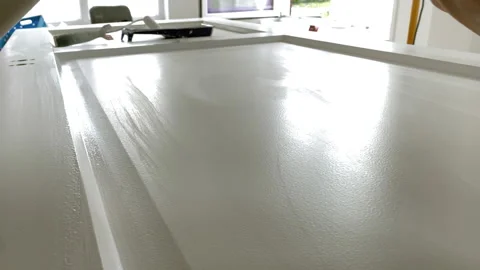 Paint brush closeup. Painter at work paints the wooden door with white paint Stock Footage 156661122