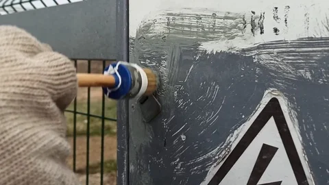 Paint brush the electrical panel with gray paint on a cloudy day . Stock Footage 119804266
