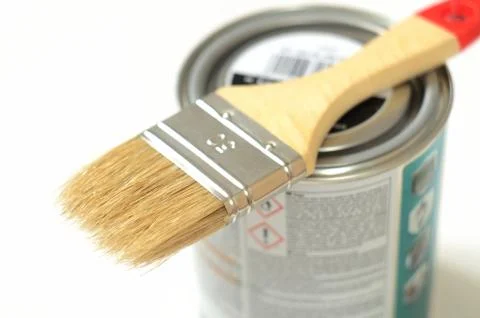 Paint brush lying on the can of paint on a white Stock Photos