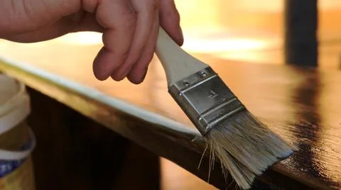 Paint brush in the process of varnish-and-paint work Stock Photos