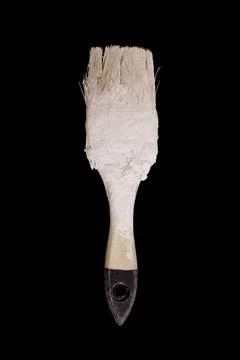 Paint brush in white paint isolate on black background Stock Photos