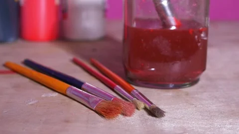 Paint brushes and cleaning jar on a table Stock Footage 163368871