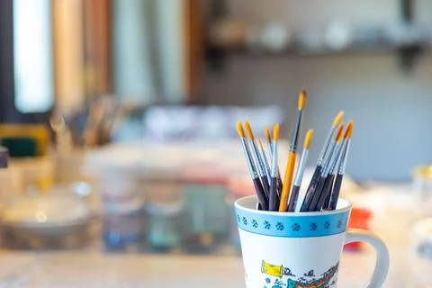 Paint brushes of different sizes in glasses, art background concept Stock Photos