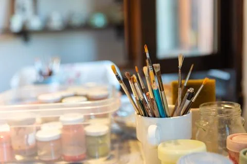 Paint brushes of different sizes in glasses, art background concept Stock Photos