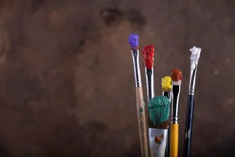 Paint brushes in front of blurred canvas Stock Photos