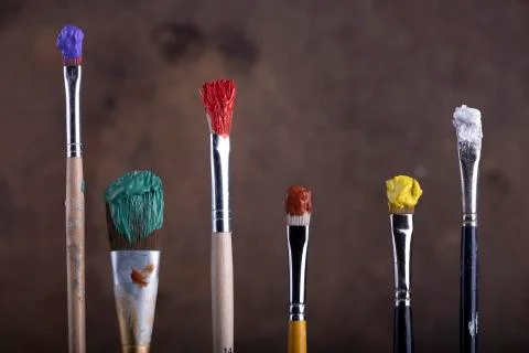 Paint brushes in front of blurred canvas Stock Photos