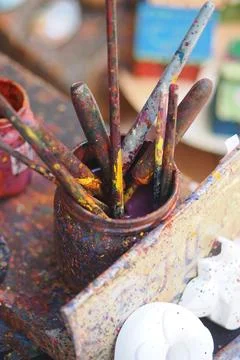 Paint brushes in a jar on a workspace table Stock Photos