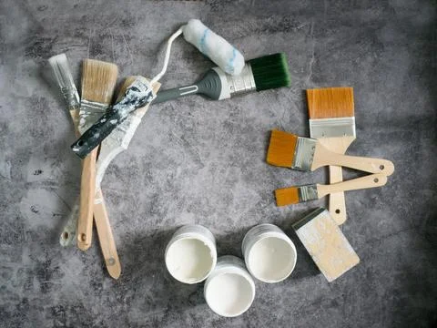 Paint brushes , roller and paint samples on stone floor background Stock Photos