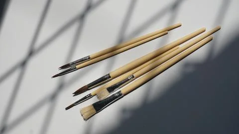 Paint brushes on a white background with a shadow from the window Stock Photos