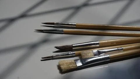 Paint brushes on a white background with a shadow from the window Stock Photos
