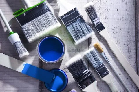 Paint can and paintbrushes of different size  for home decorating purposes. Stock Photos