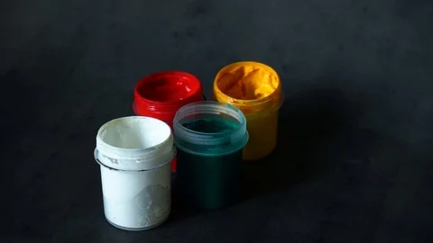 Paint can. colored cans with paint on black background. artist's accessories. Stock Footage 99237716