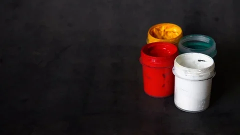 Paint can. colored cans with paint on black background. artist's accessories. Stock Footage 99237717