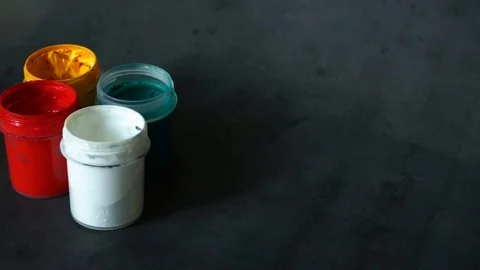 Paint can. colored cans with paint on black background. artist's accessories. Stock Footage 99237719