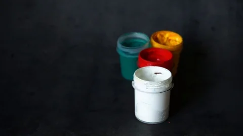 Paint can. colored cans with paint on black background. artist's accessories. Stock Footage 99237720