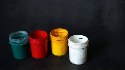Paint can. colored cans with paint on black background. artist's accessories. Stock Footage 99237722
