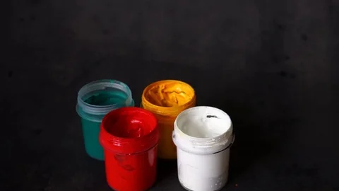 Paint can. colored cans with paint on black background. artist's accessories. Stock Footage 99237725