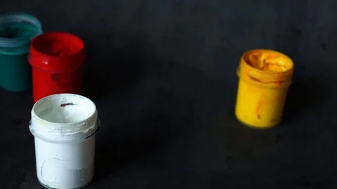 Paint can. colored cans with paint on black background. artist's accessories. Stock Footage 99237727