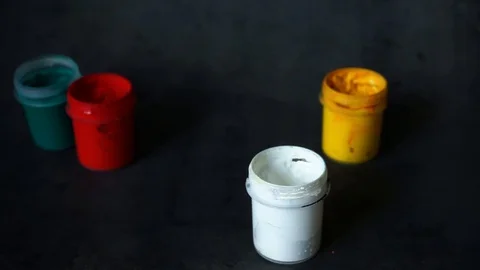 Paint can. colored cans with paint on black background. artist's accessories. Stock Footage 99237729