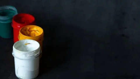 Paint can. colored cans with paint on black background. artist's accessories. Stock Footage 99237730