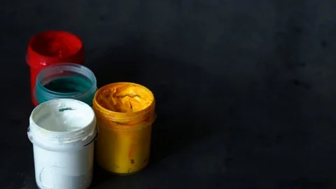 Paint can. colored cans with paint on black background. artist's accessories. Stock Footage 99237732