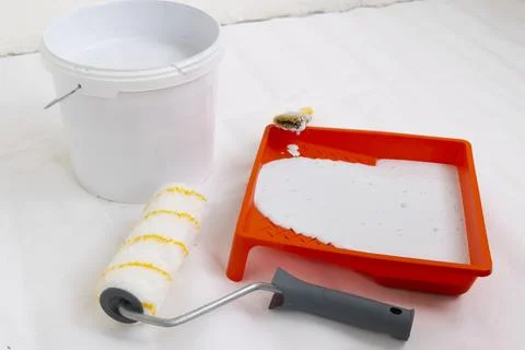 Paint can, roller and paint tray for painting wall on the floor Stock Photos