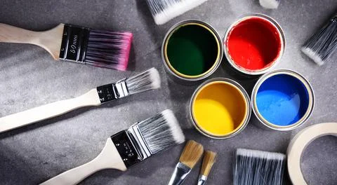 Paint cans and paintbrushes of different size  for home decorating purposes. Stock Photos