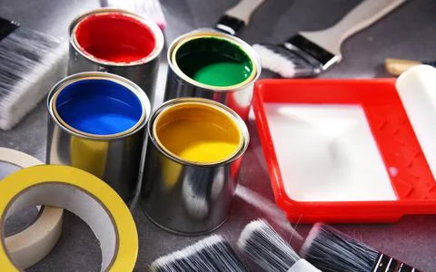 Paint cans and paintbrushes of different size  for home decorating purposes. Stock Photos