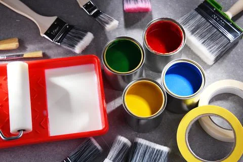 Paint cans and paintbrushes of different size  for home decorating purposes. Stock Photos