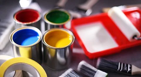 Paint cans and paintbrushes of different size  for home decorating purposes. Stock Photos