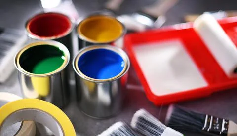 Paint cans and paintbrushes of different size  for home decorating purposes. Stock Photos