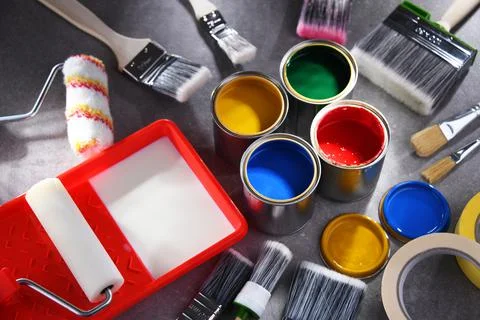 Paint cans and paintbrushes of different size  for home decorating purposes. Stock Photos