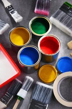 Paint cans and paintbrushes of different size  for home decorating purposes. Stock Photos